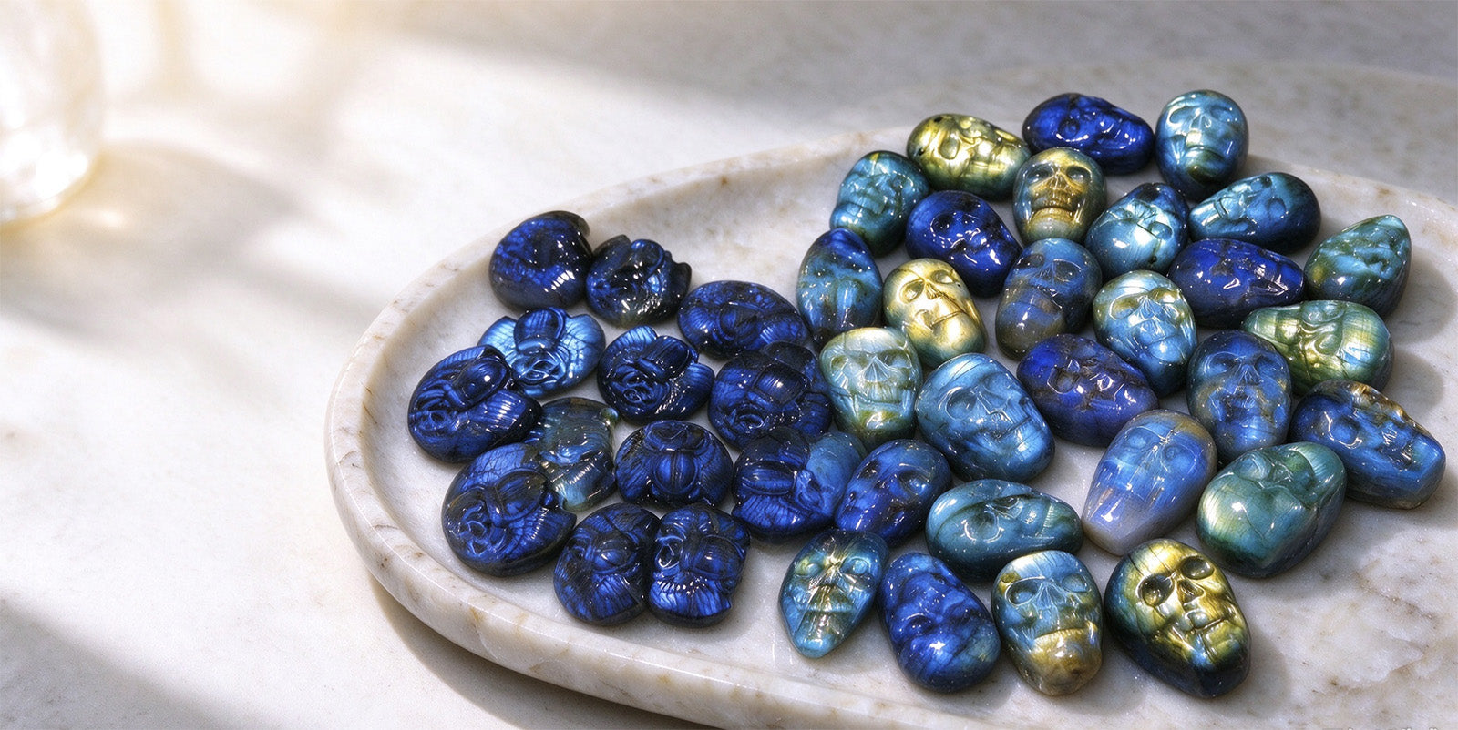 Blue and gold carved skull stones on a marble plate